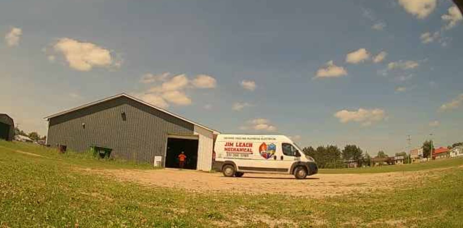 White Ram ProMaster van with Jim Leach Mechanical graphics parked outside a shop building