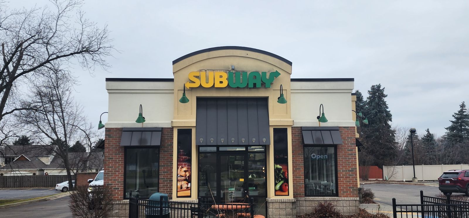 Subway restaurant storefront with signs, daytime
