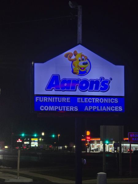 Lit Aaron's pylon sign reading Furniture, Electronics, Computers, Appliances at night