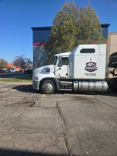 White Mack sleeper cab semi truck with American Cargo and Services door lettering, eagle logo, and USDOT and MC numbers