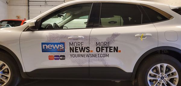 White Ford Escape with NewsNet door graphics