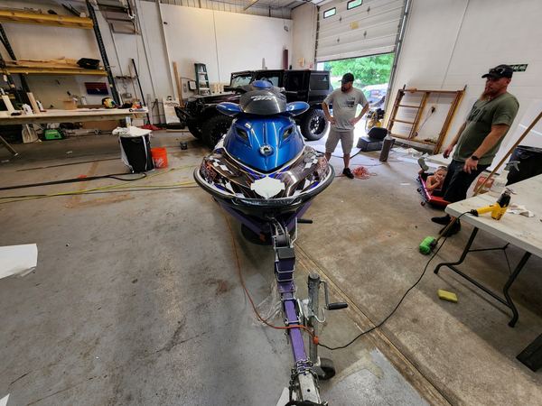 Sea-Doo jet ski on a trailer in the shop with custom graphics, front view