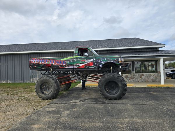 Monster truck named Short Fused with a full custom printed wrap featuring flag and green graphics