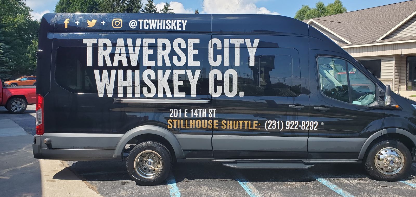 Black Ford Transit van with Traverse City Whiskey Co. lettering